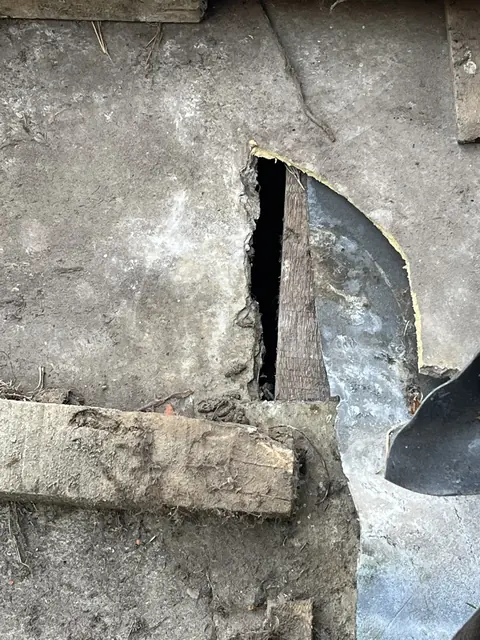 Beschadigde metalen bekleding bij een muur