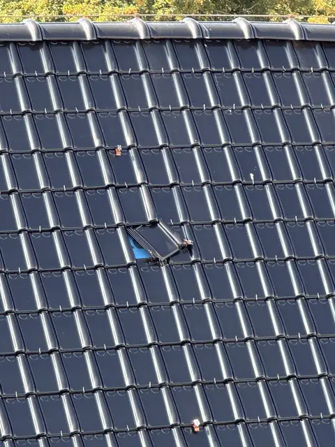 Zwarte dakpannen met een verschoven dakpan