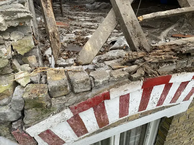 Rotte houten dakconstructie boven een gevelboog